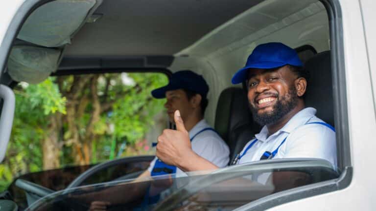 Professional movers smiling in a truck, ready to assist with heavy object moving for Abe Lincoln Movers.