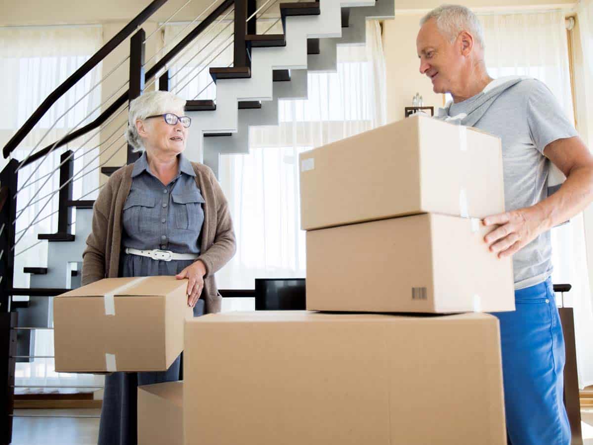 An elderly couple packing up boxes