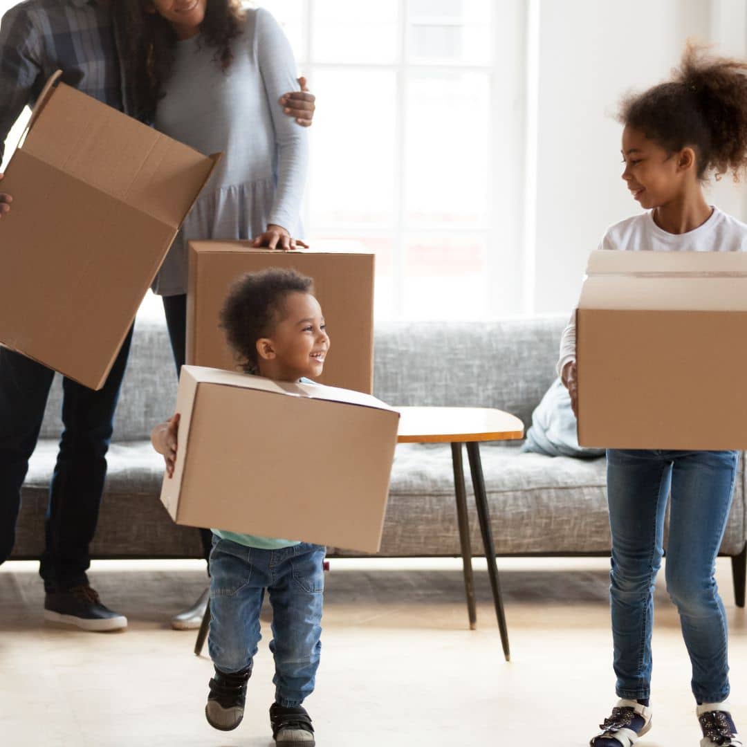 Family of four carrying moving boxes
