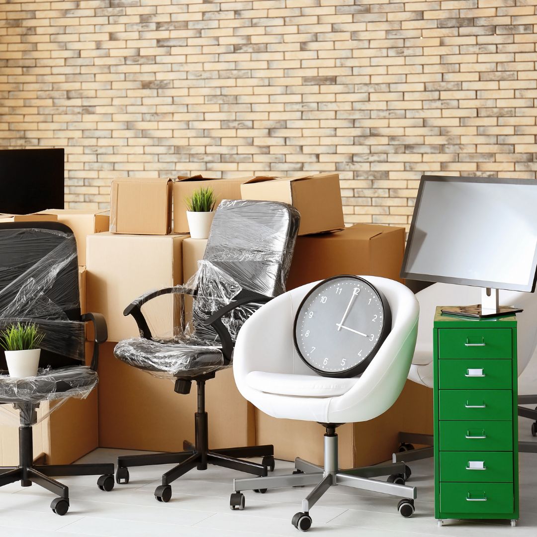 office furniture and computers sitting on moving boxes