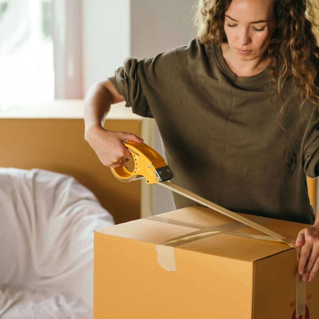 woman taping up moving boxes