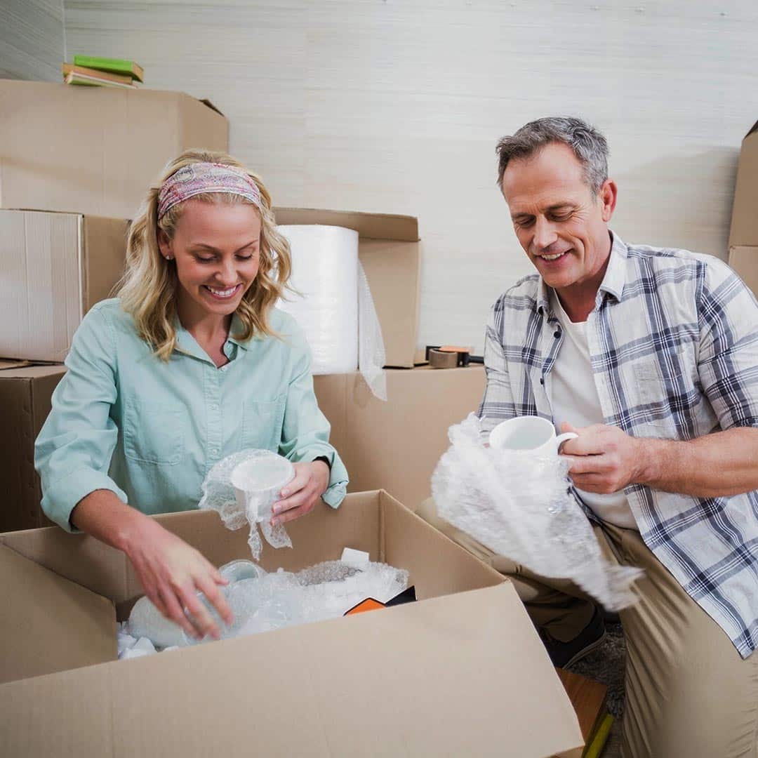 Couple packing dishes into box