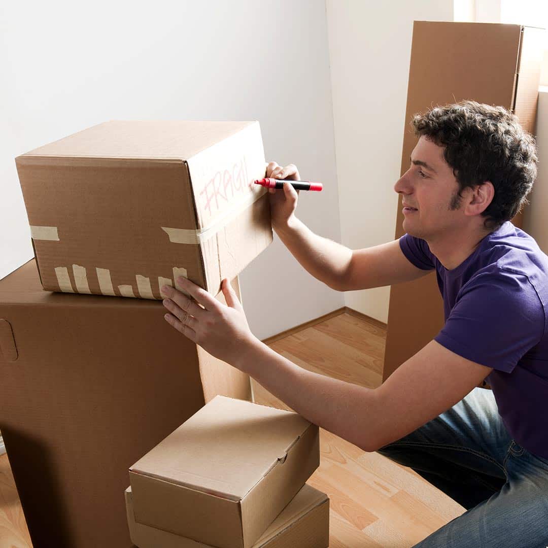 Man writing on boxes with markers