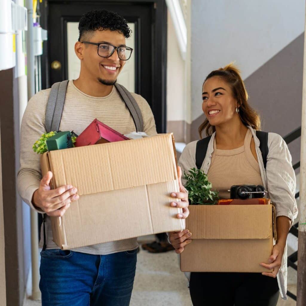 A young couple moving light boxes of important items into their new home