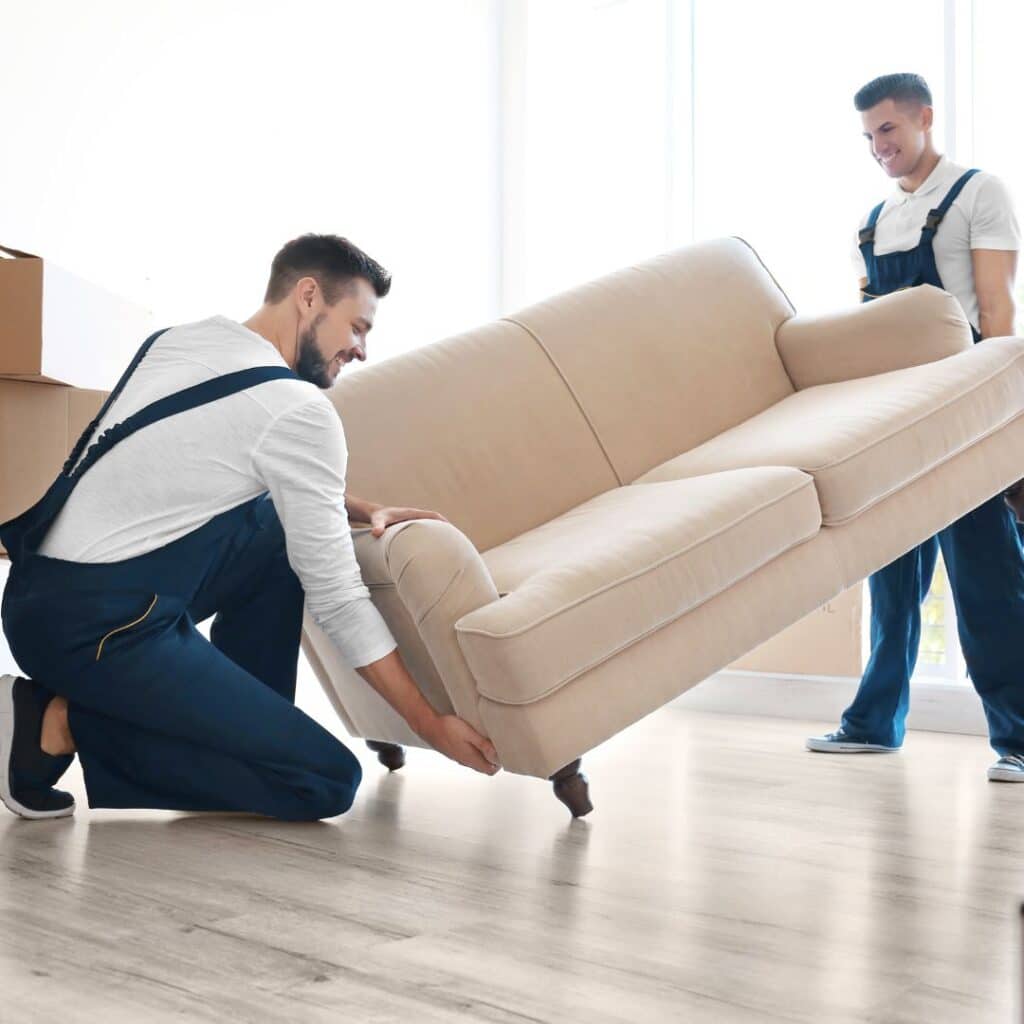 Two professional movers picking up a couch
