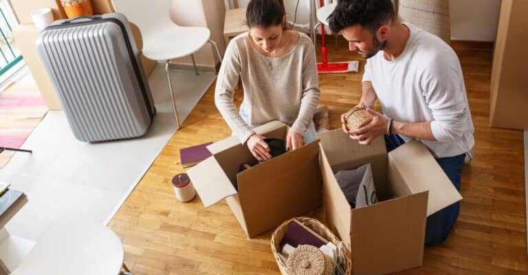 Two people packing boxes to move