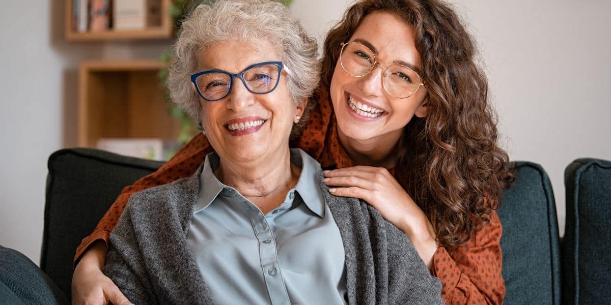 A happy elderly mother and her daughter embracing, showcasing family support during the moving process.