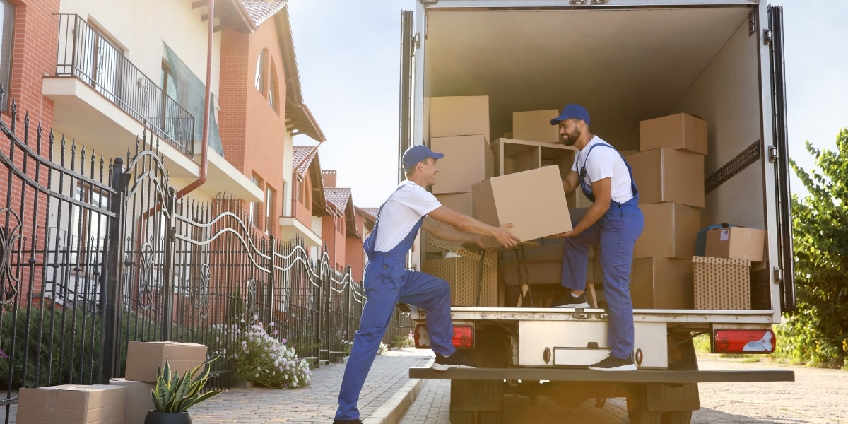 Professional movers from a reliable moving company carefully loading boxes into a moving truck at a residential property, demonstrating the expert service Abe Lincoln Movers provides throughout Colorado.